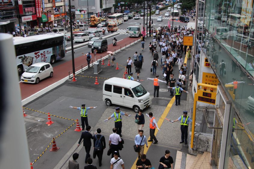 Seven people stopping pedestrians for a passing car